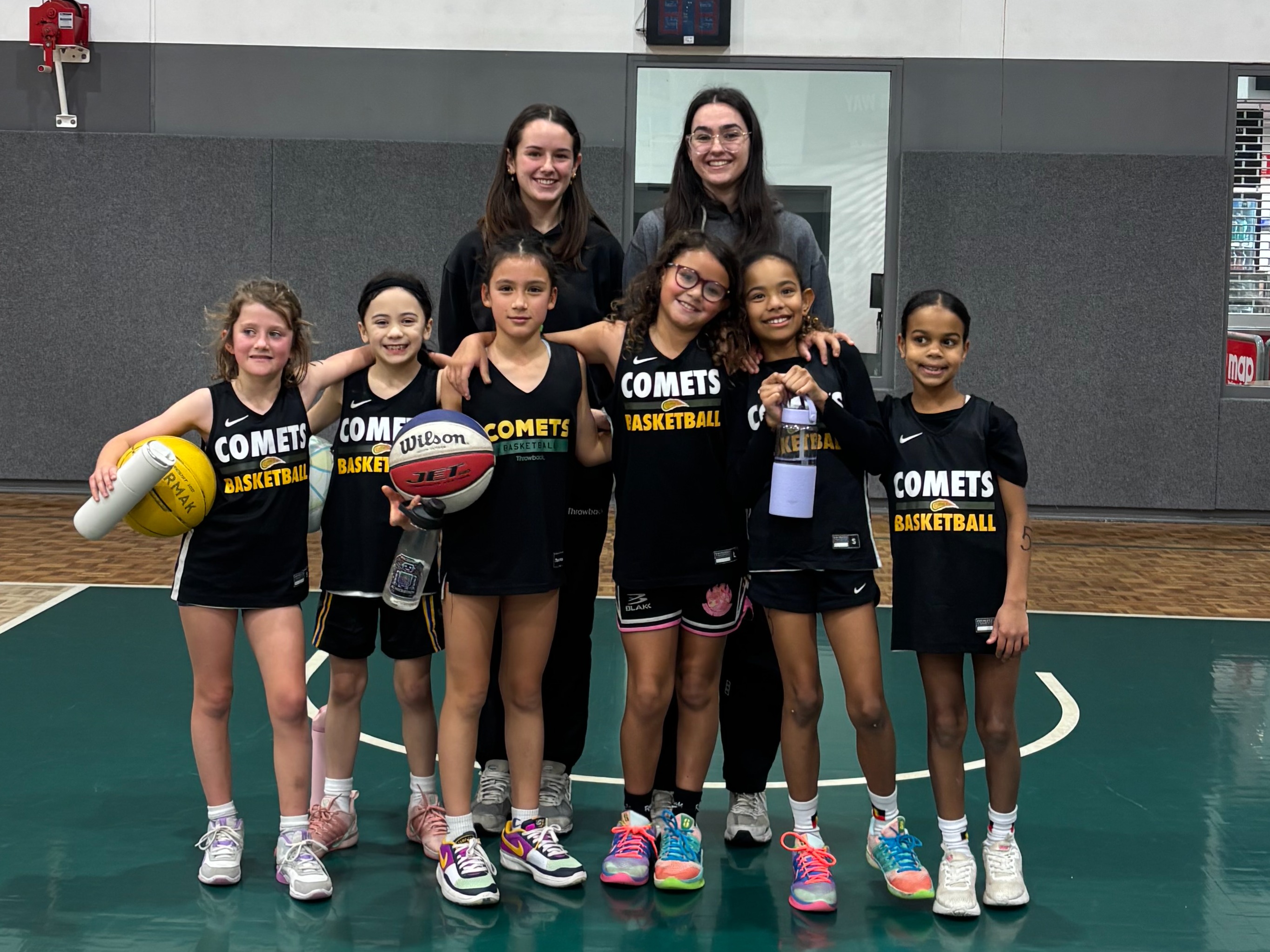 Six youth basketball players standing together on the court wearing their official Sydney Comets Rep Rookies basketball uniforms.
